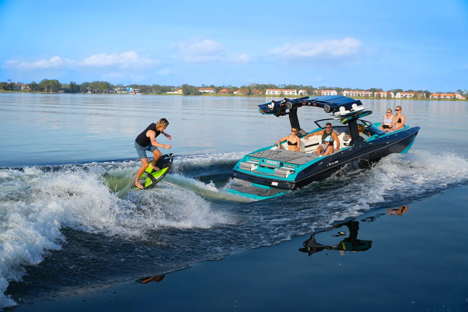 A person wakesurfing behind a boat on a calm lake.
